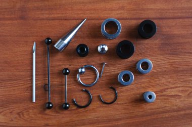 Ahşap arka plan piercing Piercing aksesuarları için ayarlayın. dil ve kaş, küpe bir çubuk için bir kateter   