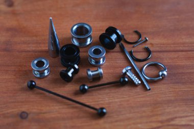 Ahşap arka plan piercing Piercing aksesuarları için ayarlayın. dil ve kaş, küpe bir çubuk için bir kateter   