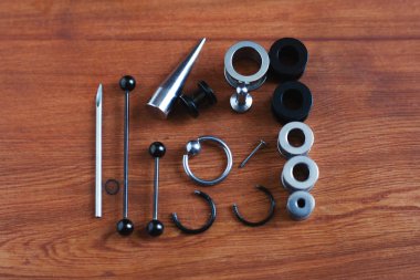 Ahşap arka plan piercing Piercing aksesuarları için ayarlayın. dil ve kaş, küpe bir çubuk için bir kateter   