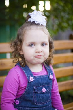 başında beyaz bir yay ile portre küçük kız kamera utangaç gülümsüyor