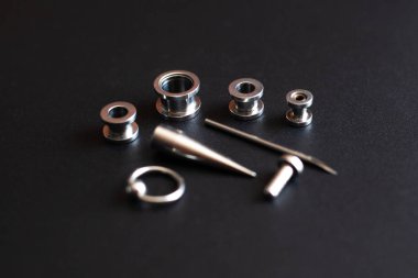 koyu bir arka plan üzerinde piercing için aksesuar seti