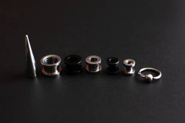 koyu bir arka plan üzerinde piercing için aksesuar seti