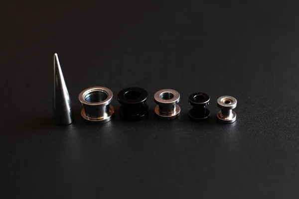 Set of accessories for piercing on a dark background — Stock Photo, Image