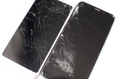 beyaz arka plan üzerinde beyaz ve siyah iki kırık telefonlar. dokunmatik ekranın kırık dokunmatik cam izole