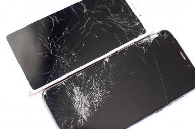 beyaz arka plan üzerinde beyaz ve siyah iki kırık telefonlar. dokunmatik ekranın kırık dokunmatik cam izole