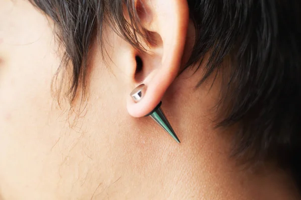 Rozciąganie uszu dla tuneli o większej średnicy, piercer ręcznie wstawia piercing w uchu — Zdjęcie stockowe