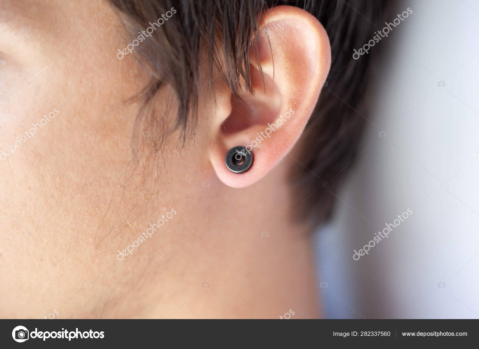 Draaien Vlucht Defecte Piercing in the ear, tunnels in the ears of a young man lifestyle Stock  Photo by ©fukume 282337560