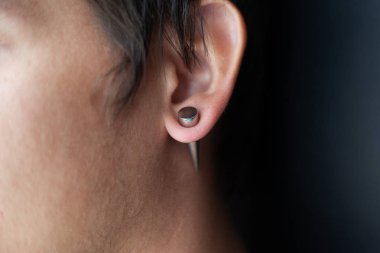 piercing in the ear, tunnels in the ears of a young man lifestyle clipart