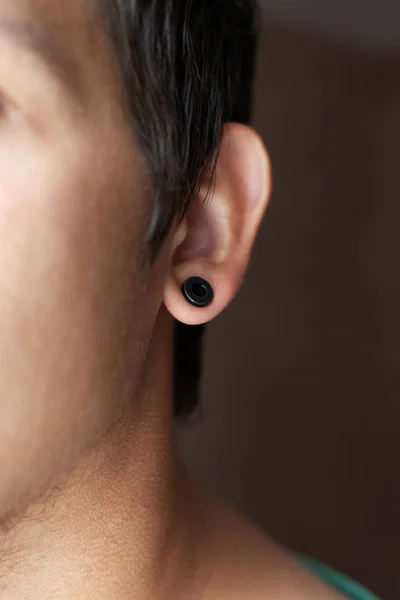 Menusuk di telinga, terowongan di telinga gaya hidup seorang pemuda — Stok Foto