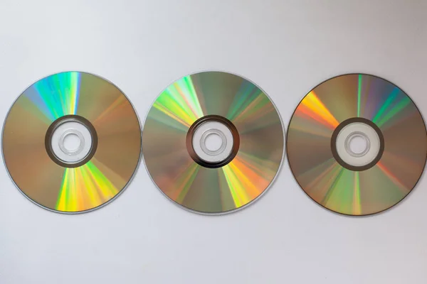 3 discos compactos de cd com drivers de computador em uma linha em um fundo branco — Fotografia de Stock