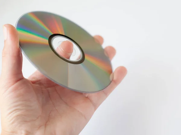 Cd compact disc con film e musica, dvd disc in mano su sfondo bianco — Foto Stock