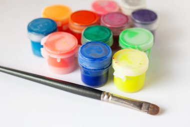 beyaz bir arka plan üzerinde guaj ve boya fırçası çok renkli tüpler