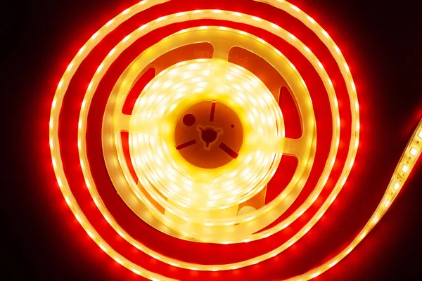 glowing LED strip on a red background, copy space top view led light