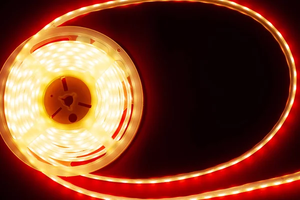 Marco brillante tira de led sobre un fondo rojo, espacio de copia vista superior led luz — Foto de Stock