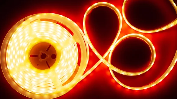 glowing LED strip on a red background, copy space top view led light