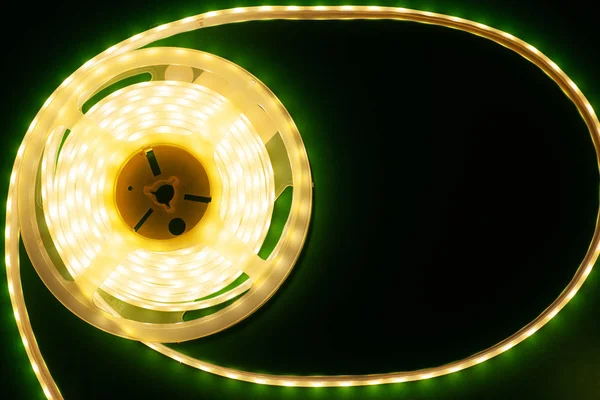 Luminosa tira led sobre un fondo verde oscuro iluminado maqueta vista superior — Foto de Stock