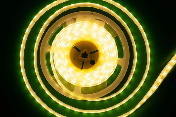 Luminosa tira led sobre un fondo verde oscuro iluminado vista superior — Foto de Stock