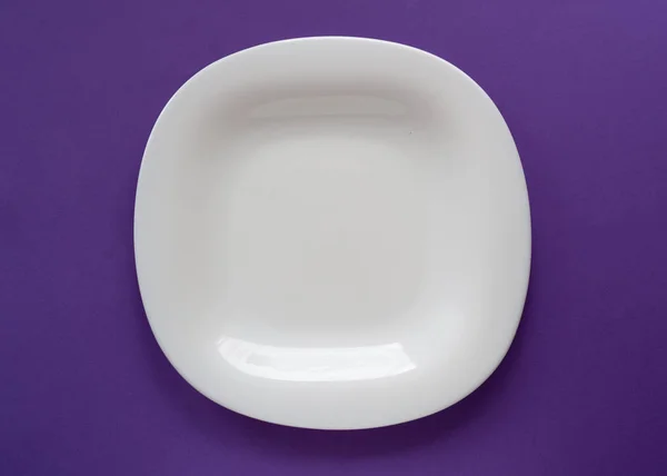 Weiße Platte flach mit Kopierraum auf violettem Hintergrund von oben — Stockfoto