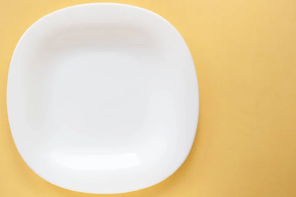 White plate with copy space on a beige background — Stock Photo, Image