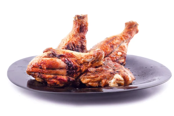 고립 된 흰색 배경에 검은 접시에 지각에 구운 닭 다리 — 스톡 사진