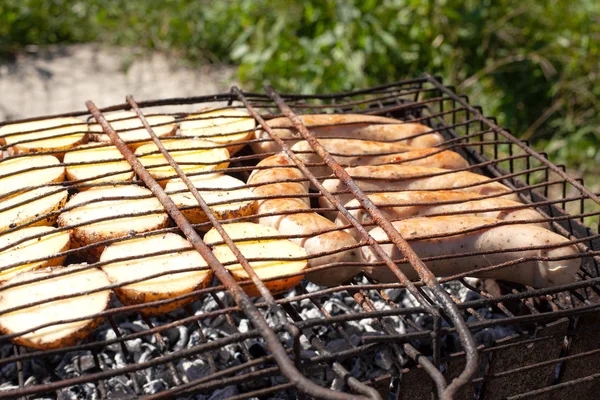 sıcak kömürler üzerinde sosis ile patates, açık havada pişirme süreci