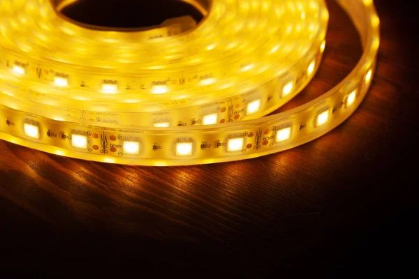 Led silikon bobin parlayan şerit. Ahşap masa üzerinde diyot ışıkları — Stok fotoğraf