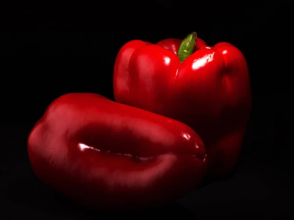 Duas pimentas vermelhas doces (páprica) em um fundo escuro fechar — Fotografia de Stock
