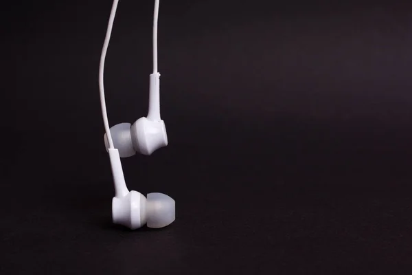 Auriculares blancos sobre fondo oscuro con espacio para copiar — Foto de Stock