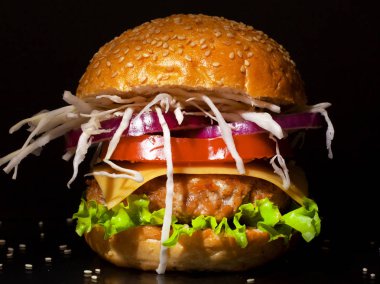 Siyah arka planda taze lezzetli bir burger.