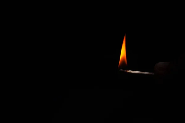 Jogo em chamas na mão sobre um fundo preto — Fotografia de Stock