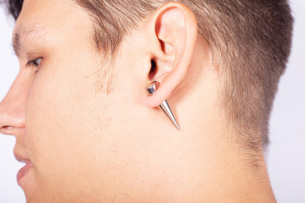 ear pierced guy,piercing stretching to increase the diameter of the tunnels