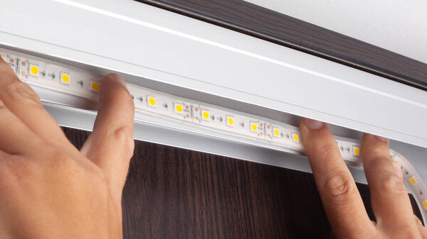 master installs LED strip in the office close-up