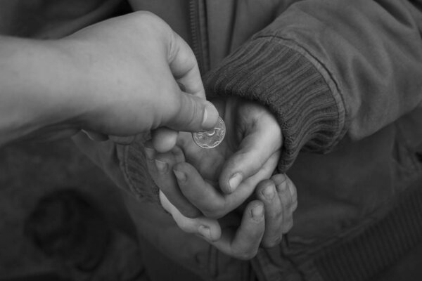 coins in the hands of a beggar,good man gives alms to the poor