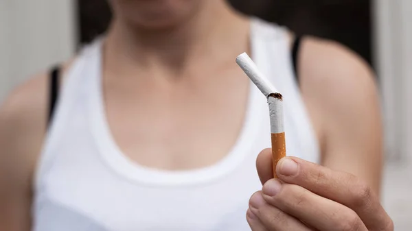 Menina segura um cigarro quebrado na mão close-up. parar de fumar, conceito de saúde, mau hábito — Fotografia de Stock