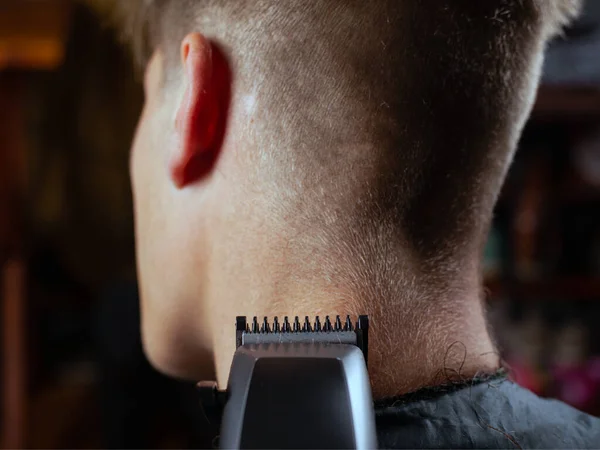 Male hairstylist serving client, making haircut using trimming machine back view — Stock Photo, Image