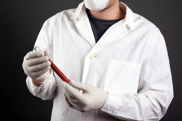 Ein Arzt in Uniform hält ein Reagenzglas mit Blut in den Händen. Analyse zur Überprüfung, covid-19 check — Stockfoto