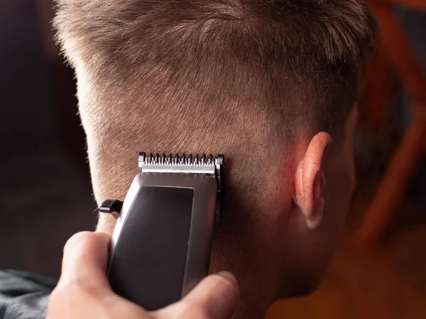 Mannen kapsel, meester knipt r een jonge man met een tondeuse close-up, kapper gereedschap — Stockfoto