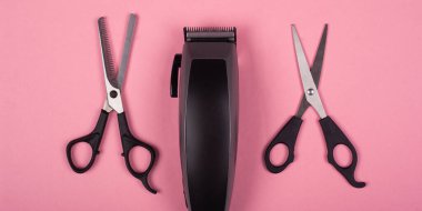 Pembe arka planda saç makası ve makas, kuaför aletleri