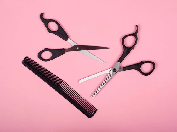 Outils de coupe de cheveux, ciseaux et peigne sur fond rose — Photo