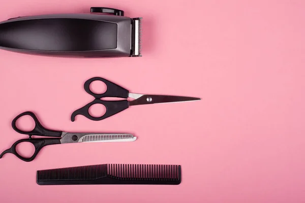 Tondeuse à cheveux, ciseaux de coiffeur droits et clairsemés et peigne sur fond rose vue de dessus, espace de copie. outils de coiffure — Photo