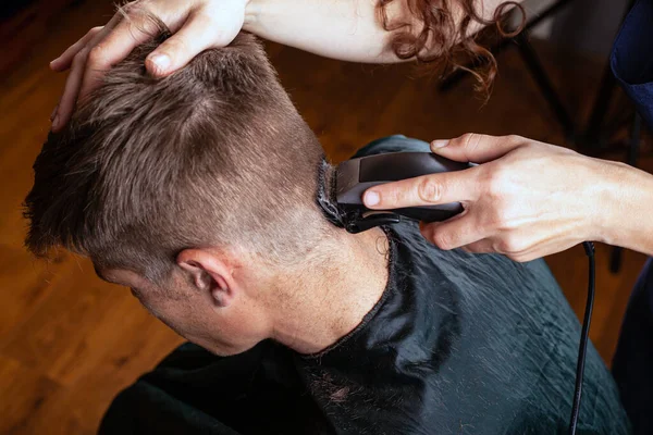 Tagliare i capelli con un trimmer sul retro della testa, parrucchiere, barbiere — Foto Stock