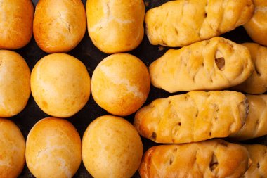 Doldurulmuş taze tatlı çörekler ve fırın örtüsü üzerinde altın kabuk.