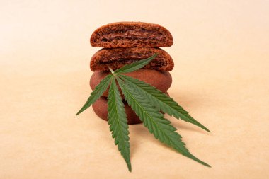 Yeşil yapraklı marihuana bitkisi olan çikolatalı kurabiyeler. Esrarlı tatlılar, bir yığın kurabiye.