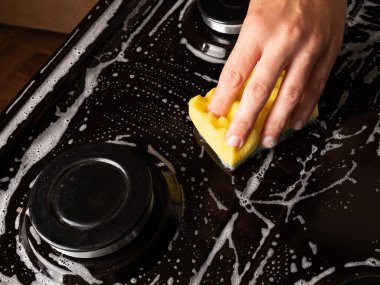 Mutfağı temizlemek, gaz sobasının yüzeyini bir bez ile temizlemek, ev aletleri.