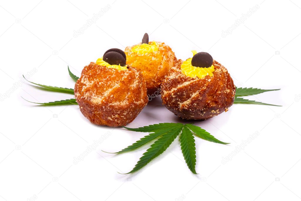 fresh sweet baked goods with marijuana, three cupcakes with cannabis plant leaves isolated on white background, sweets, dessert