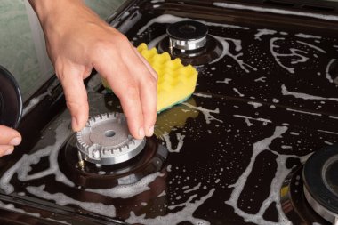 Mutfaktaki gaz sobasını yıkıyorum. 