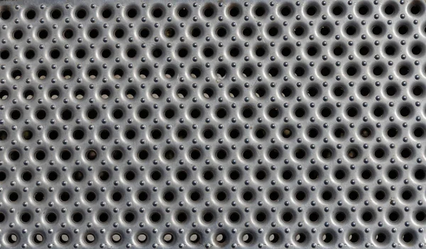 Yakın bir görünümünü delikli ve patterend parlak metal sac. Bir arka plan olarak kullanmak için uygun.