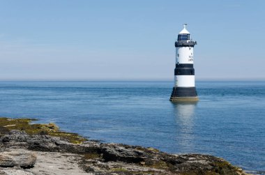 Anglesey görünümünde bazı kıyı ile Penmon feneri bir parlak, güneşli, yaz gününde.