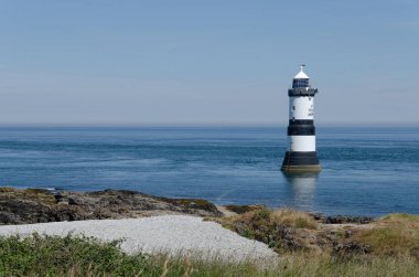 Anglesey görünümünde bazı kıyı ile Penmon feneri bir parlak, güneşli, yaz gününde.
