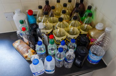 North Wales, İngiltere: 17 Temmuz 2018: boş bir mutfak tezgah atılması için hazır plastik şişe. Ortalama İngiltere'de ev her yıl 480 plastik şişe kullanır, ancak yalnızca yaklaşık 270 onları geri dönüştürür.